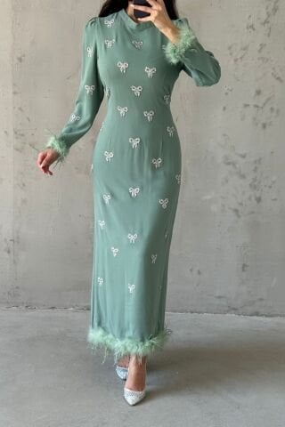 فستان سهرة أسود مطرز بالريش مع حجاب باللون الأخضر النعناعي