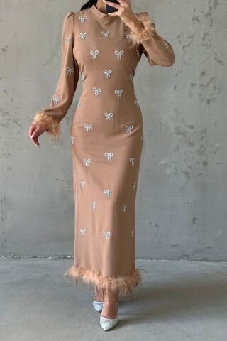 فستان سهرة أسود مزين بالريش ومطرز بحجر فيونكة كريمي اللون