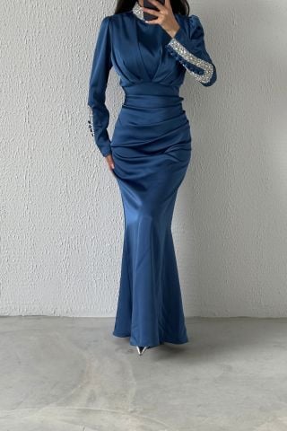 فستان سهرة من الساتان بتصميم عصري مع تفاصيل حجرية على الأكمام والياقة النيلية